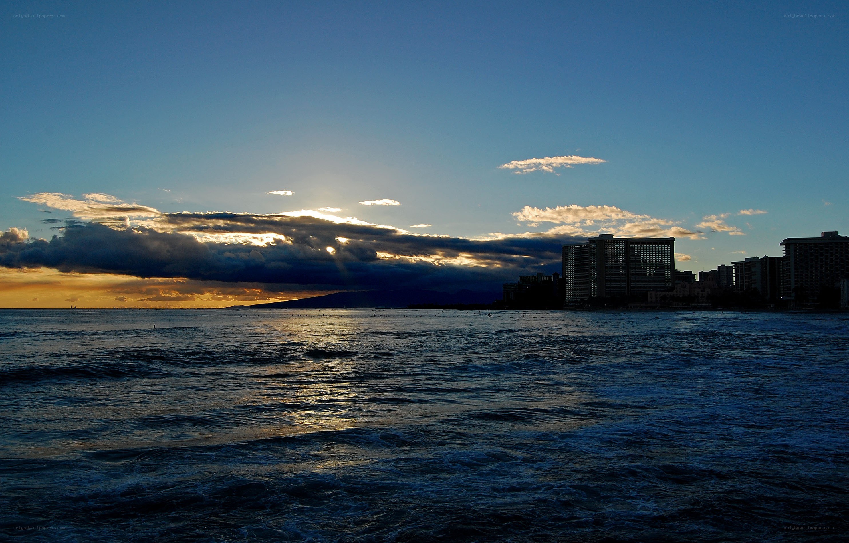 sunset over ocean cityscape