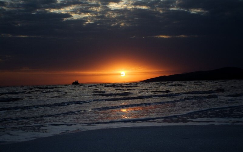 Sunset over Ocean — Orange, Dramatic, Photograph, Boat, Clouds, Mountain, Black, Blue