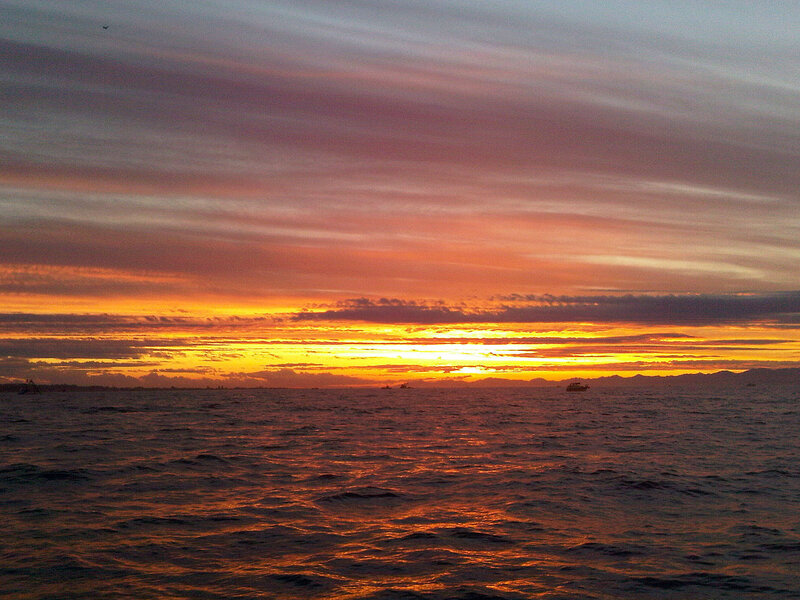 Sunset over Ocean — Orange, Dramatic, Photograph, Clouds, Boat, Mountains