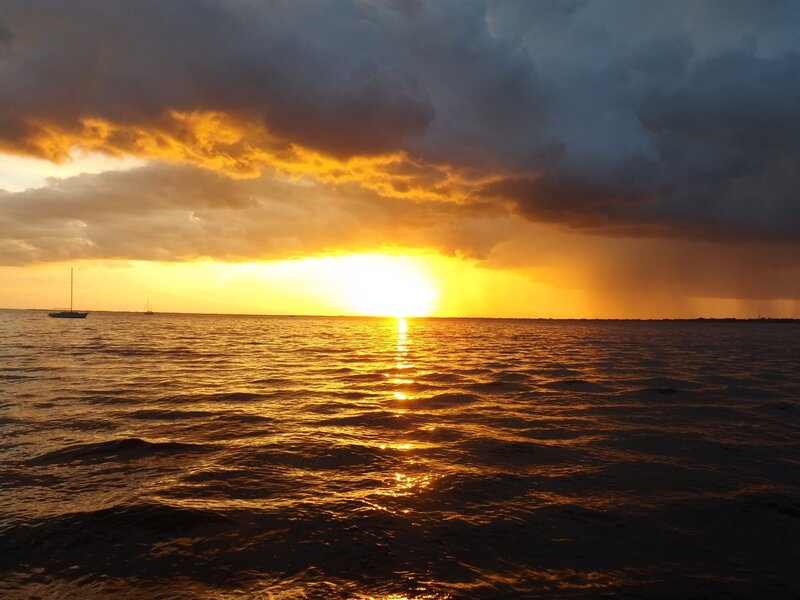 Sunset over Ocean — Orange, Dramatic, Photograph, Clouds, Boat, Rain