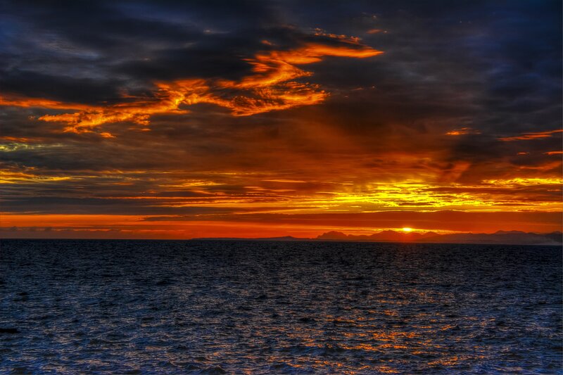 Sunset over Ocean — Orange, Dramatic, Photograph, Clouds, Mountains, Sun