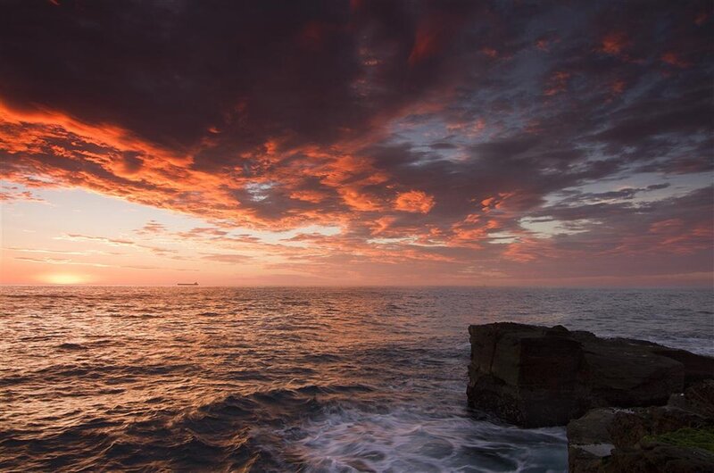 Sunset over Ocean — Orange, Dramatic, Photograph, Clouds, Ship, Rocks
