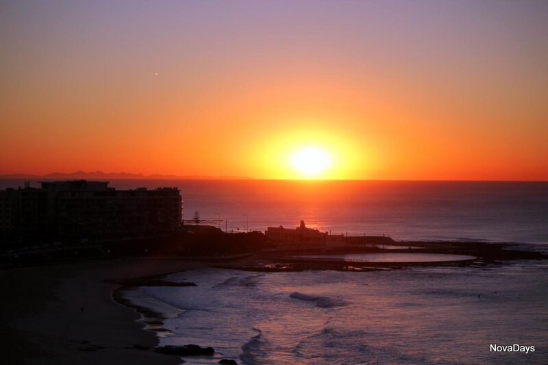 Sunset over Ocean — Orange, Serene, Photograph, Buildings
