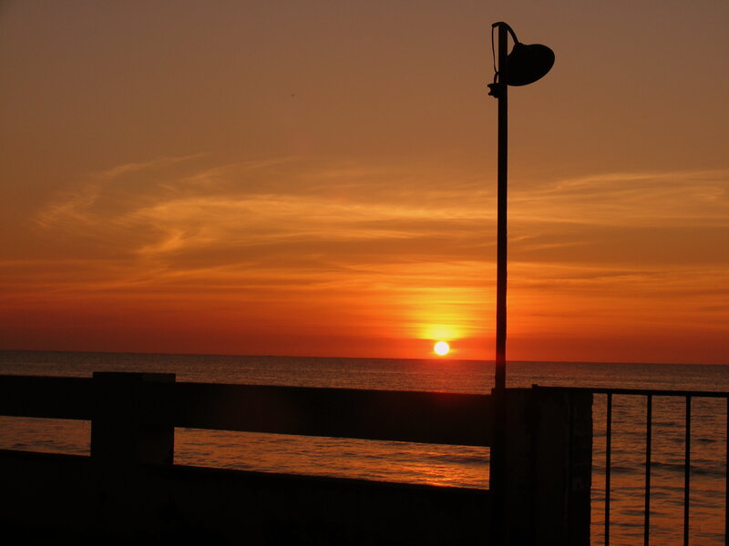 Sunset over Ocean — Orange, Serene, Photograph, Lamppost
