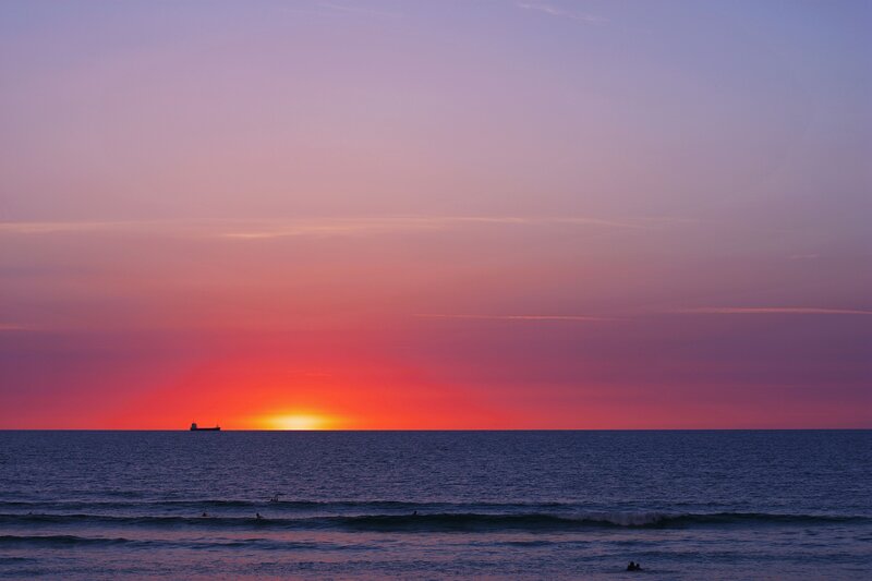 Sunset over Ocean — Purple, Serene, Photograph, Ship, Surfers