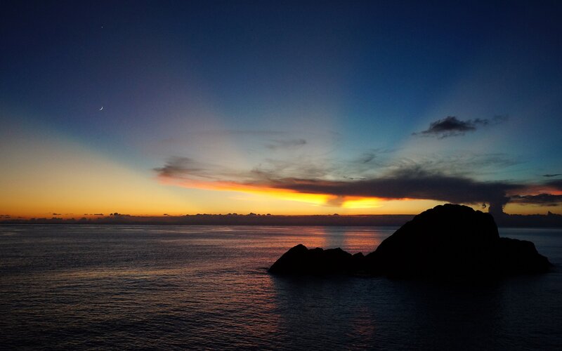 sunset over ocean with moon