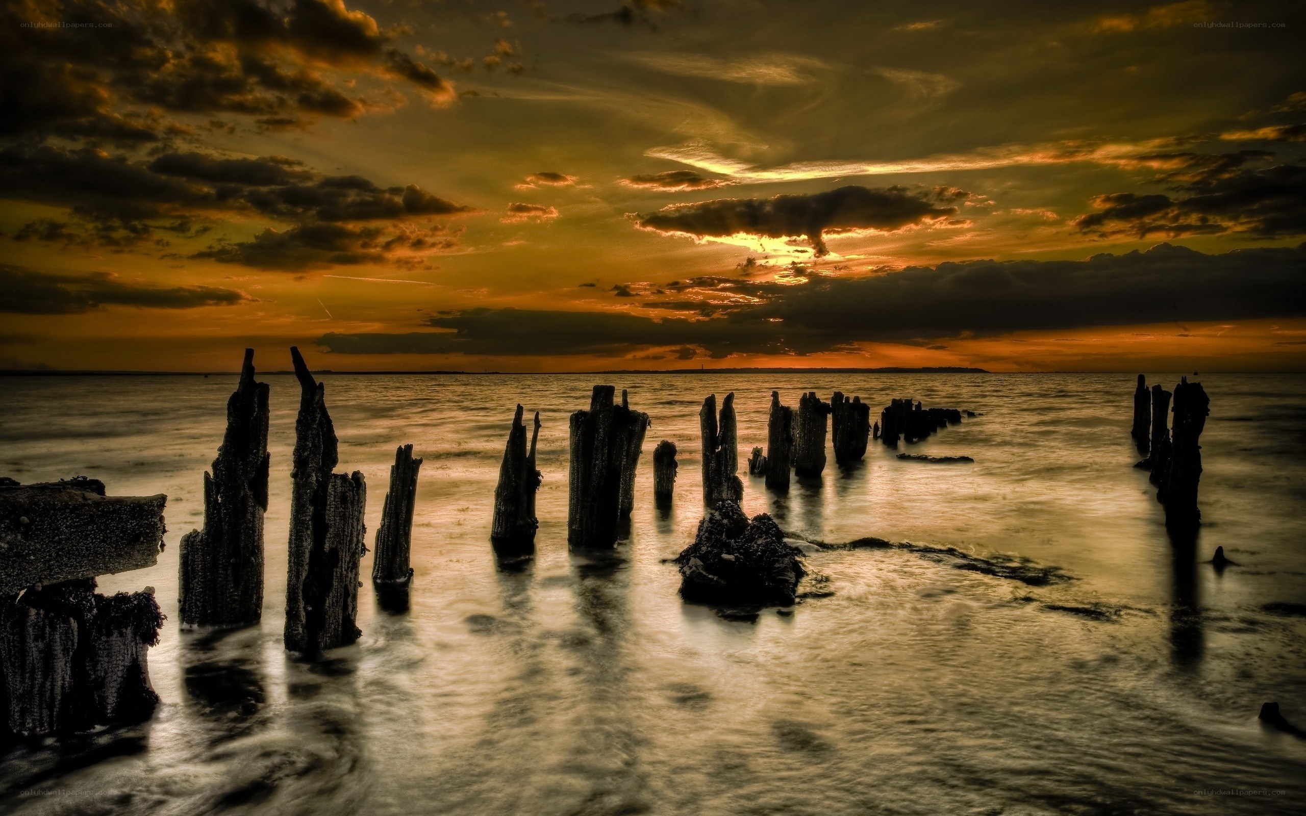 Sunset over old pier pilings