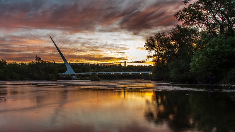 Sunset over River Bridge — Orange, Dramatic, Photograph, Trees, Person