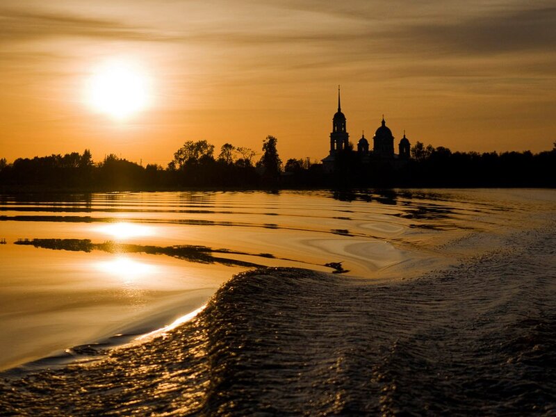 Sunset over river with church