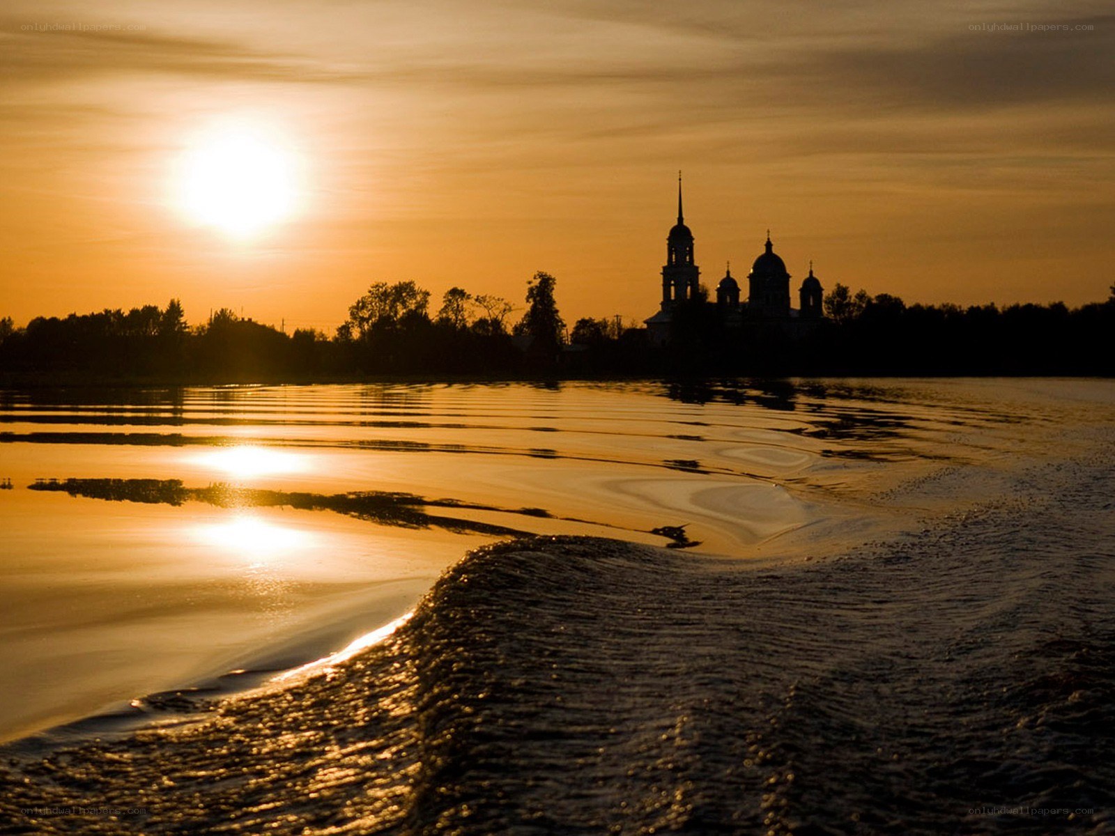 Sunset over river with church