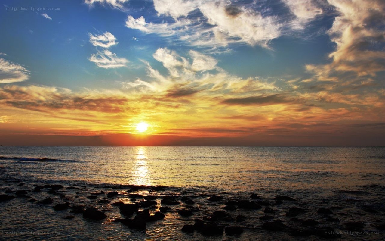 sunset over rocky beach