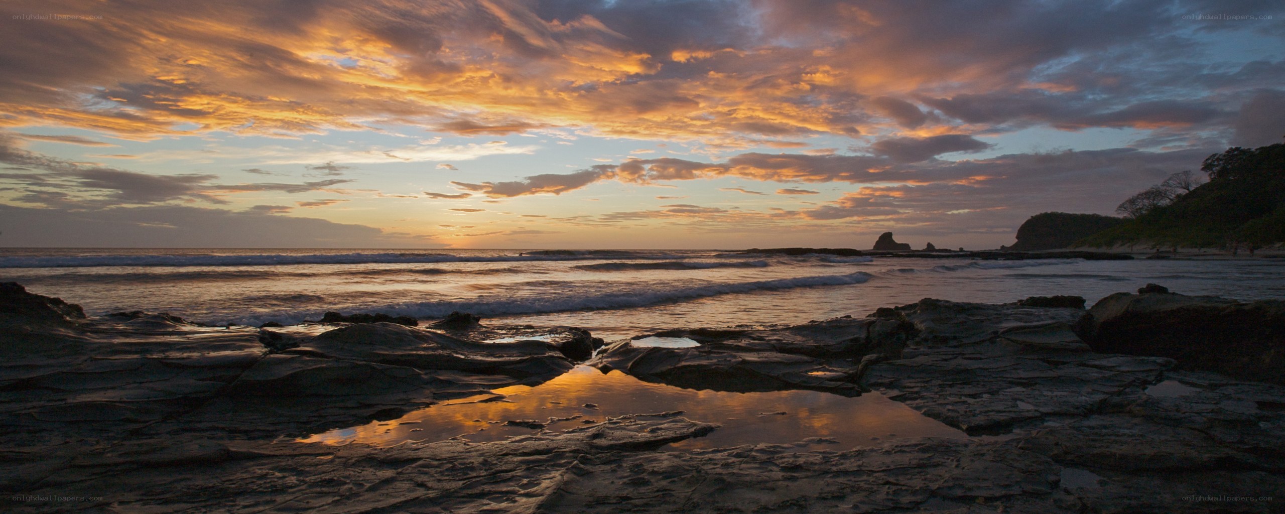 sunset over rocky beach
