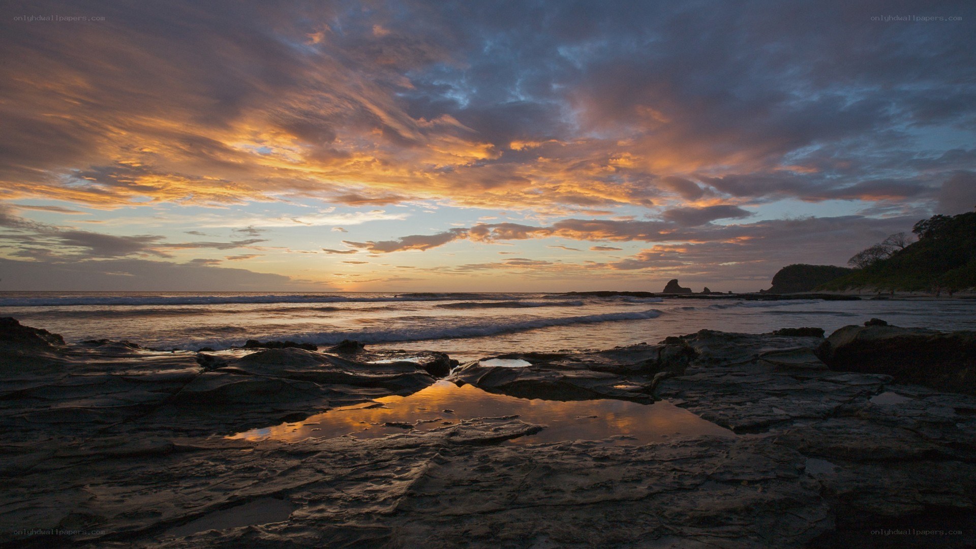 sunset over rocky beach
