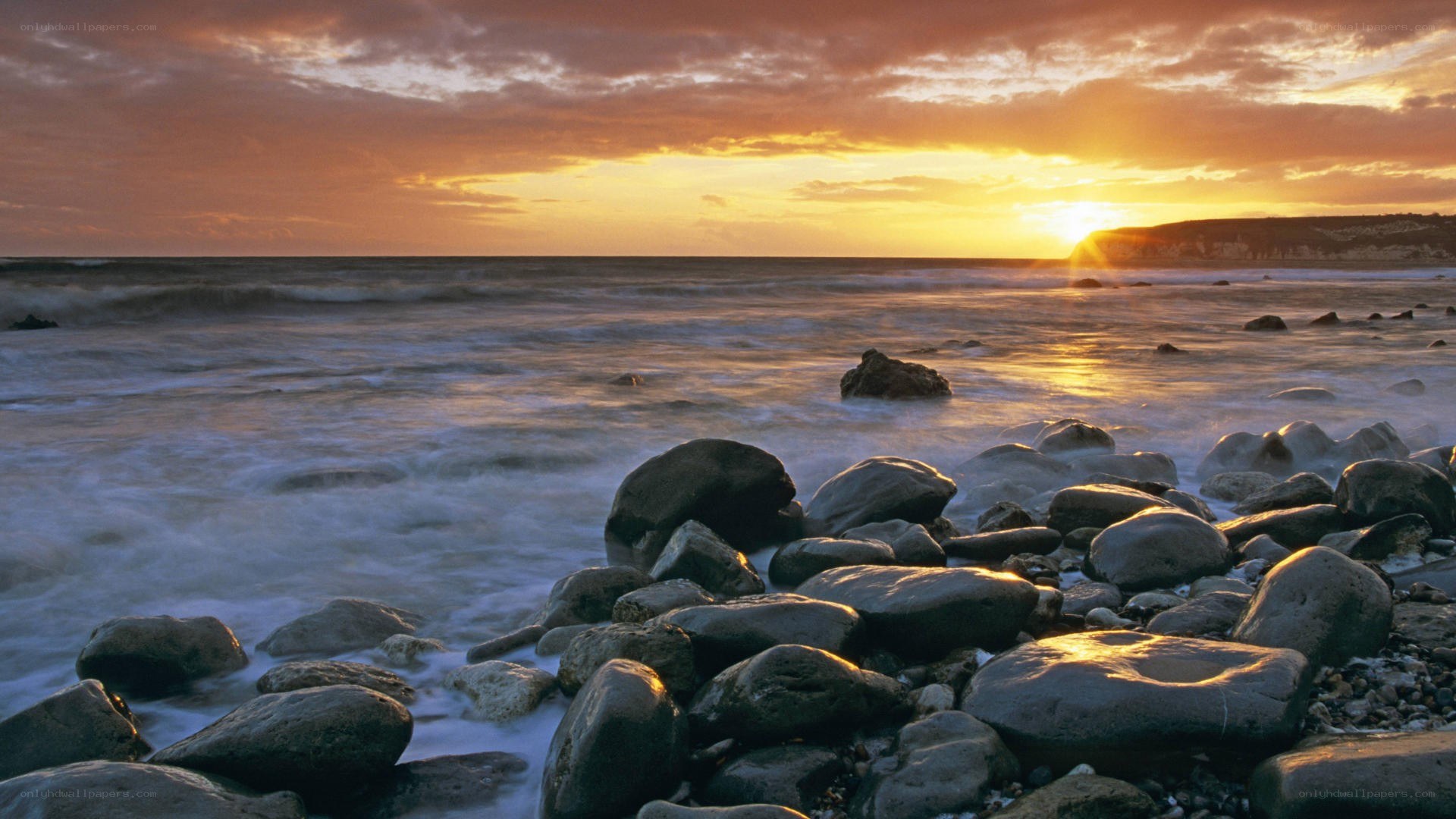 sunset over rocky beach