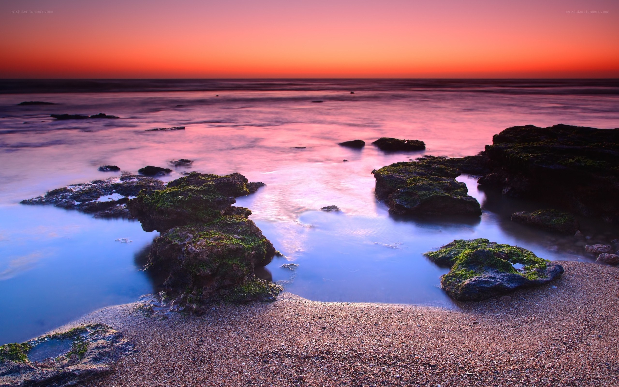 sunset over rocky beach