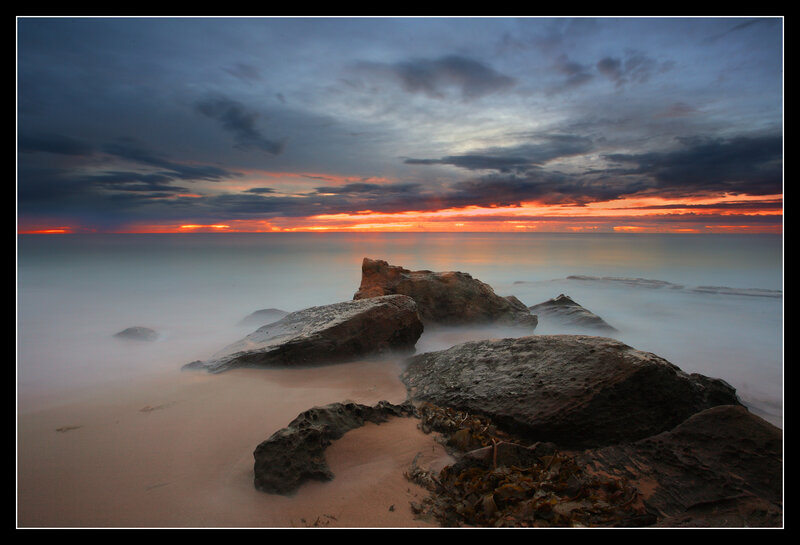 Sunset over rocky beach