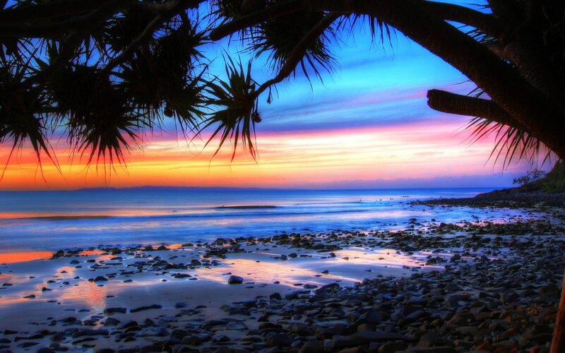 Sunset over Rocky Beach — Blue, Serene, Photograph, Palm Trees
