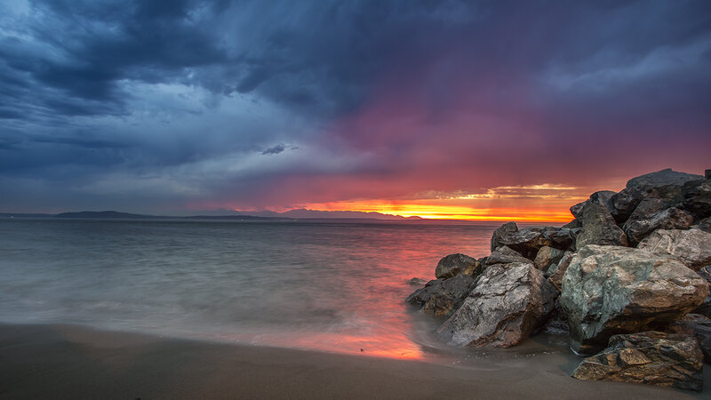 Sunset over Rocky Beach — Orange, Dramatic, Photograph, Rocks, Ocean, Sky, Mountains