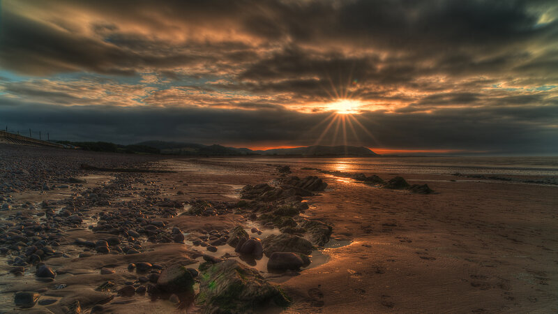 Sunset over Rocky Beach — Orange, Dramatic, Photograph, Sun, Clouds, Rocks, Sand