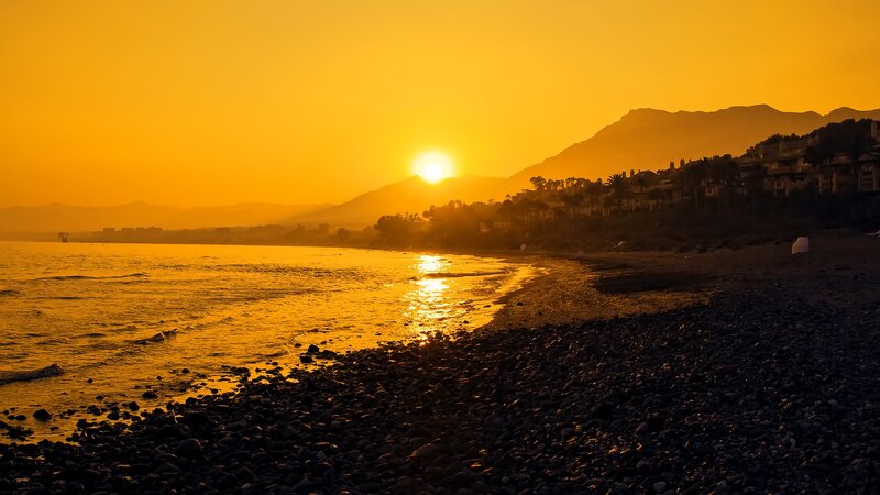 Sunset over Rocky Beach — Orange, Serene, Photograph, Mountains