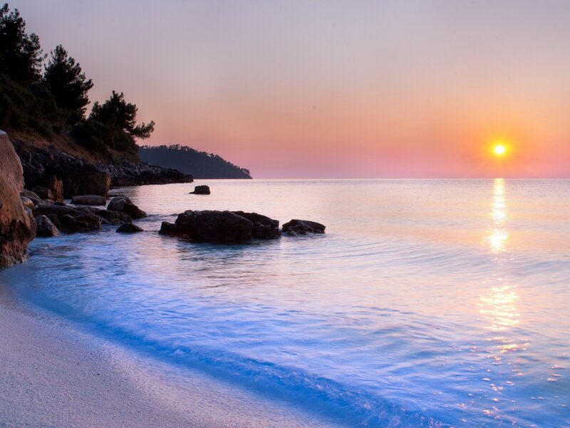 Sunset over Rocky Beach — Orange, Serene, Photograph, Sun, Rocks, Trees, Sea