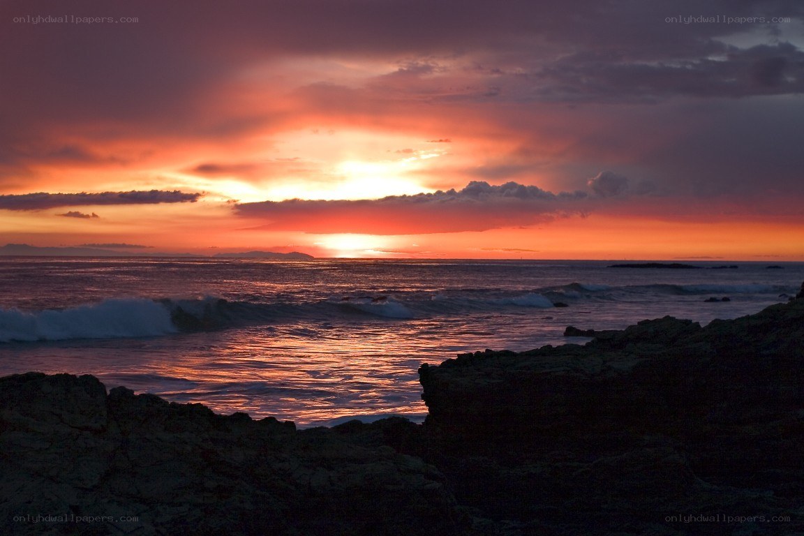 sunset over rocky coastline