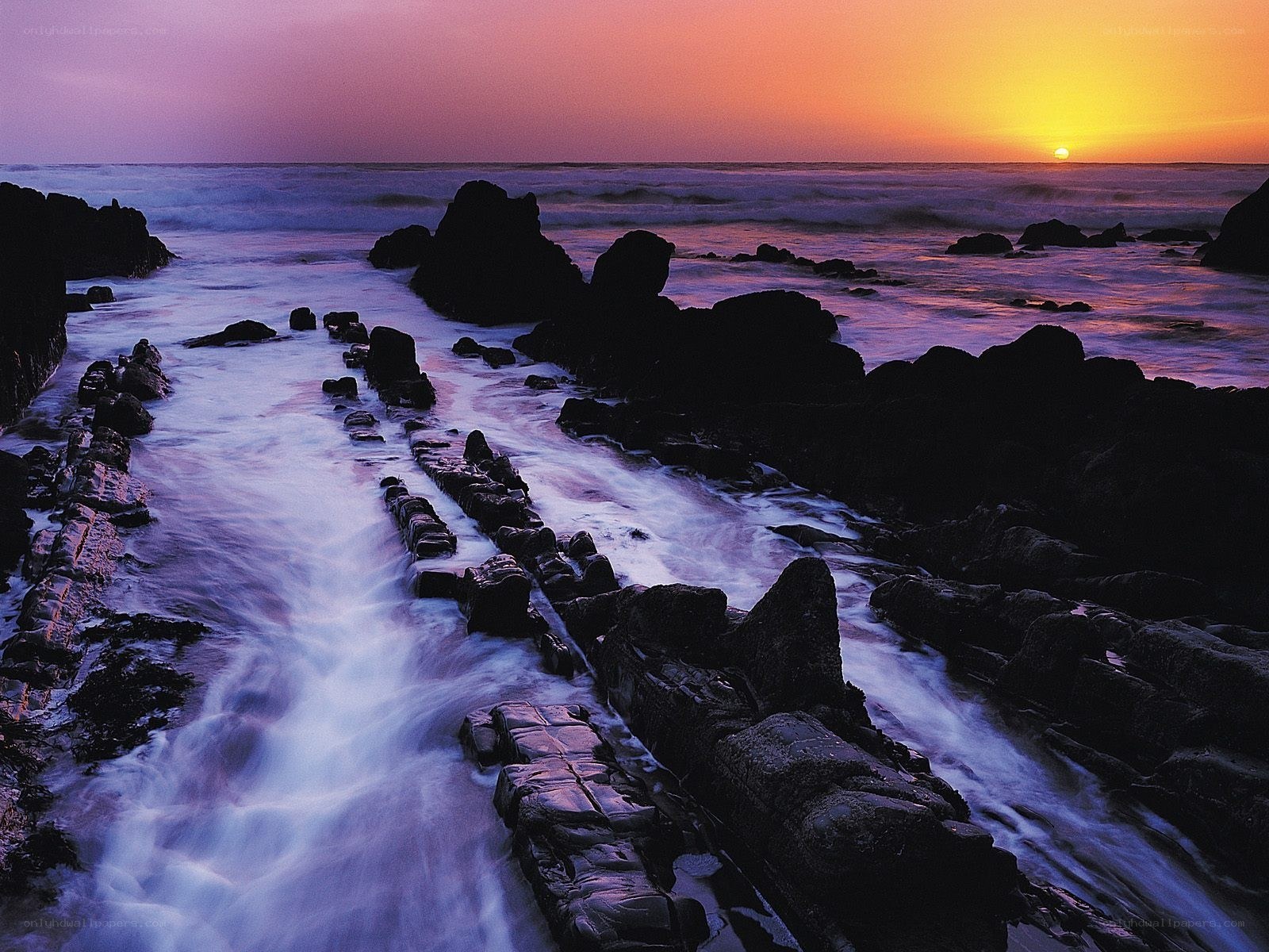 Sunset over rocky coastline