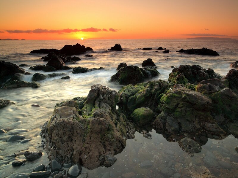 Sunset over rocky coastline