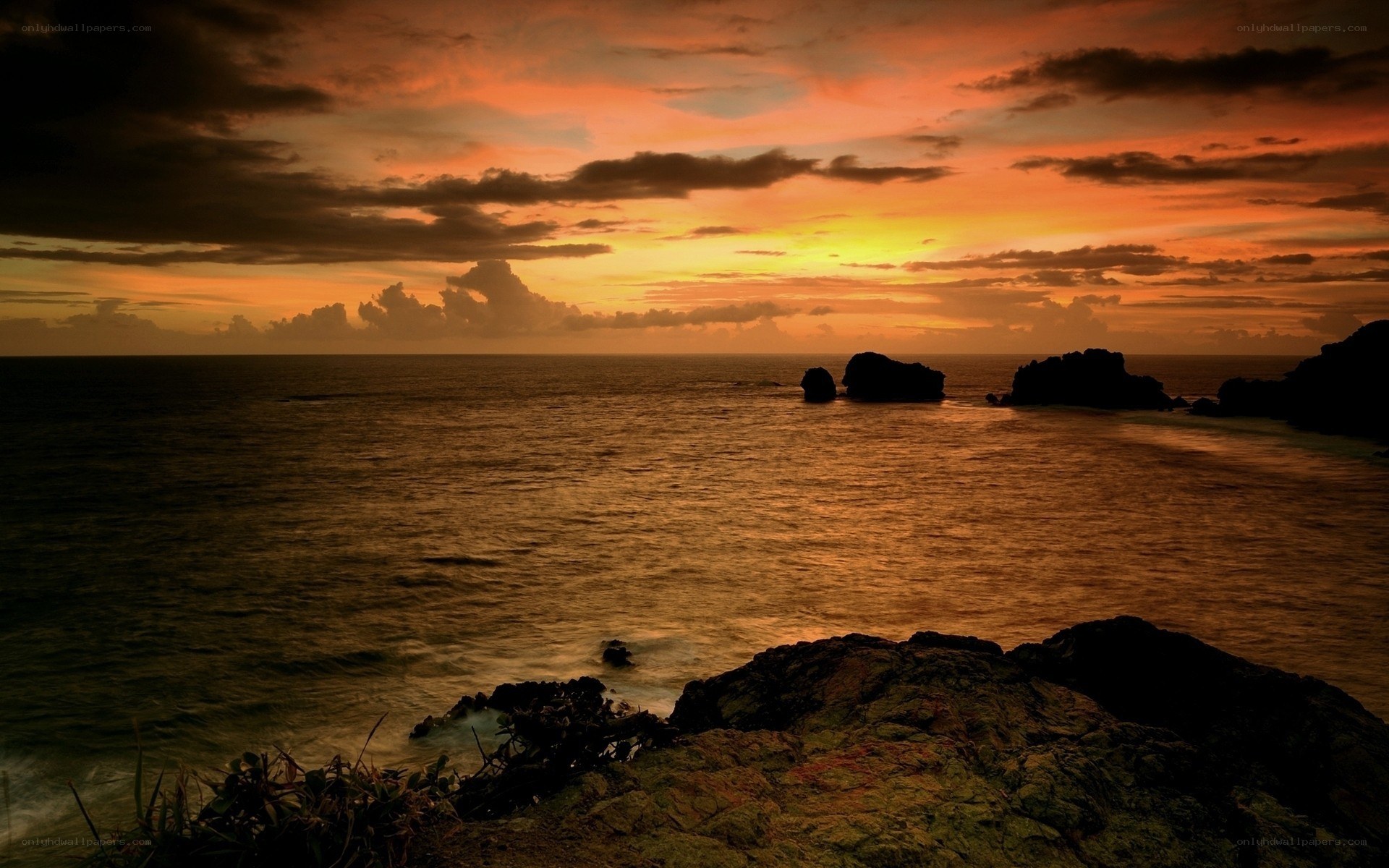 sunset over rocky coastline