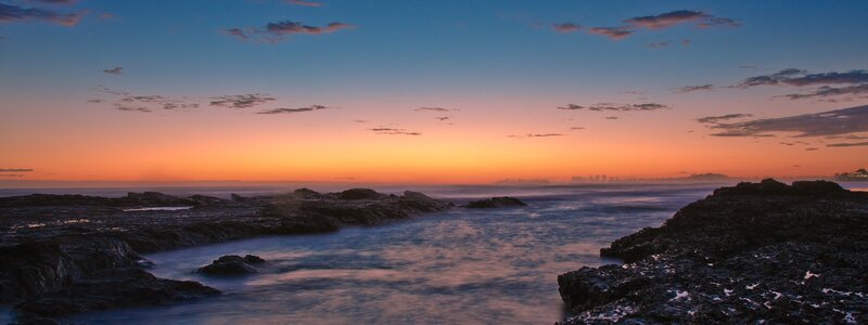 sunset over rocky coastline