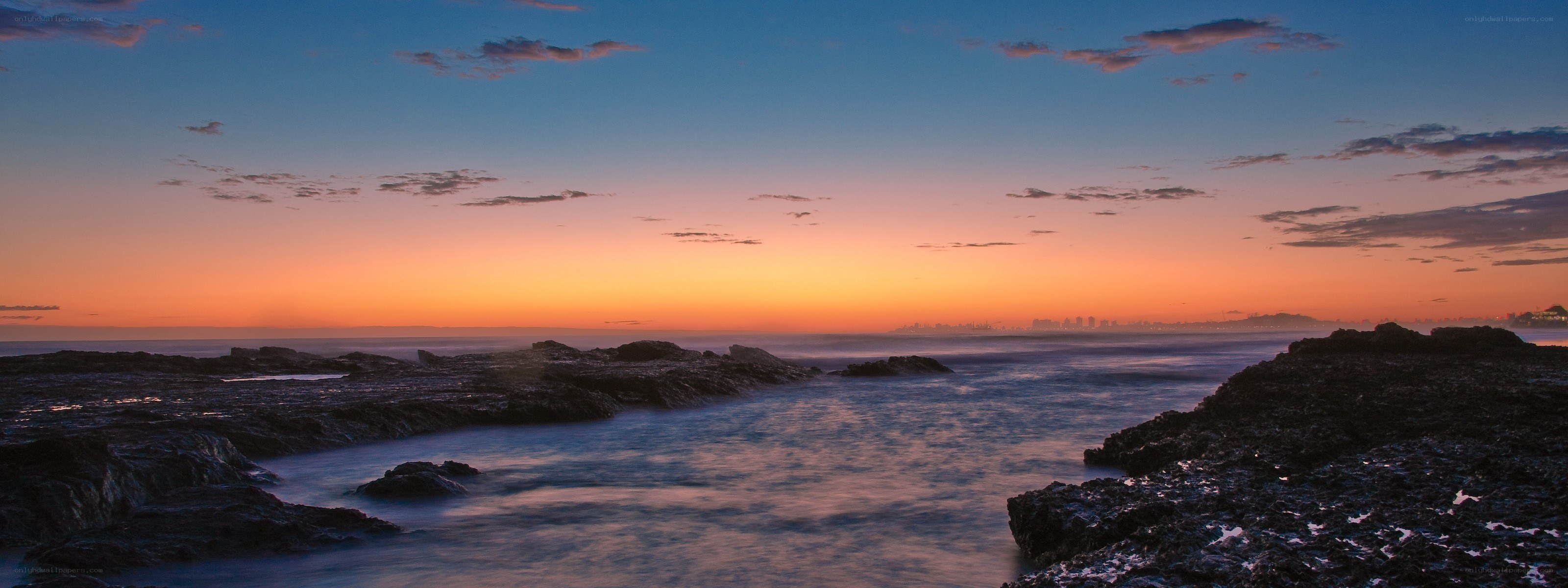 sunset over rocky coastline