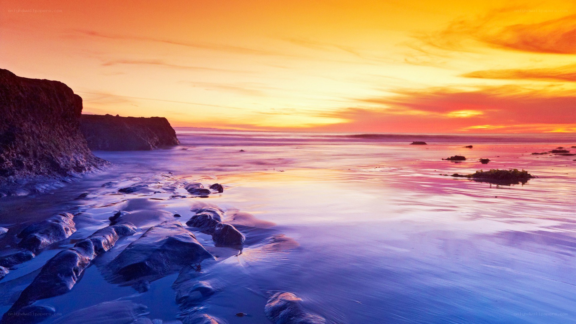 sunset over rocky coastline