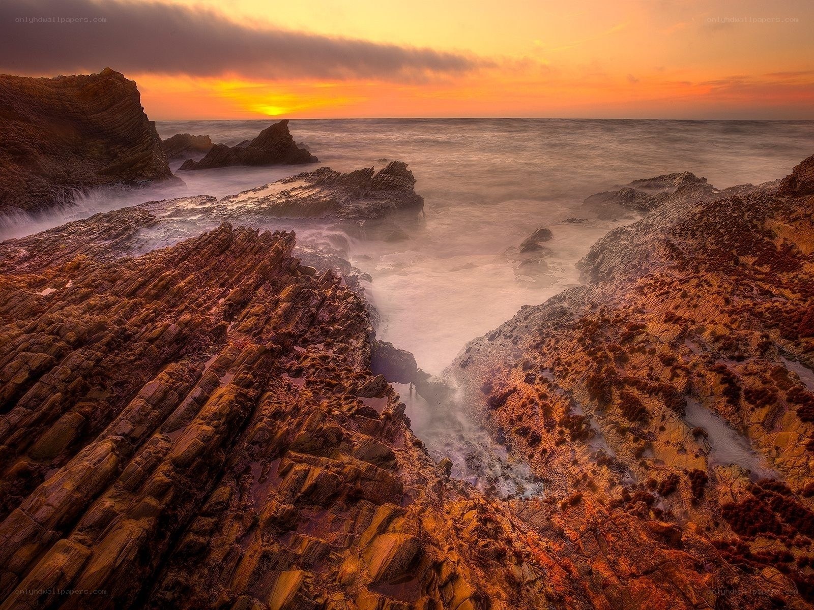 Sunset over rocky coastline