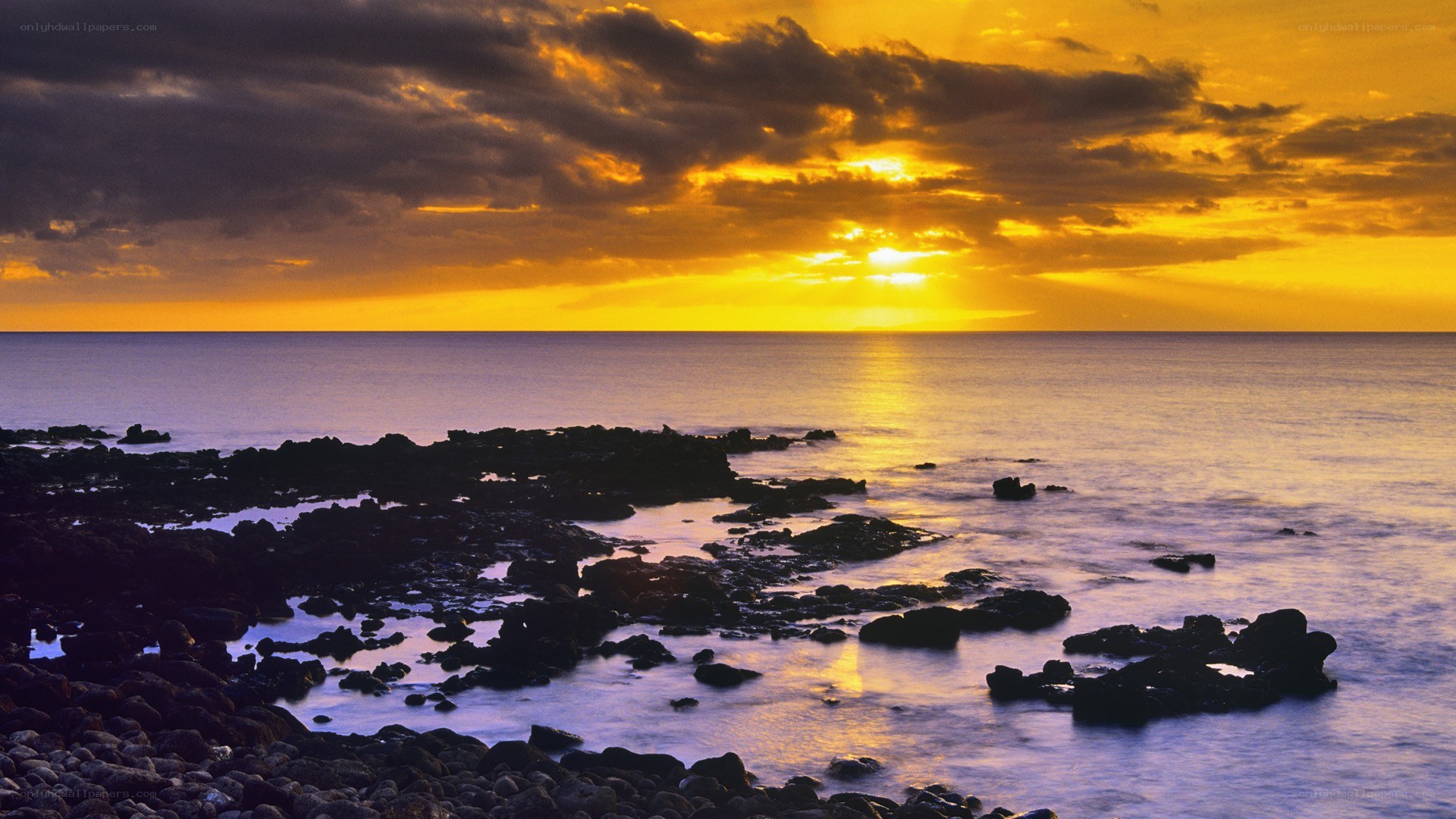 sunset over rocky coastline