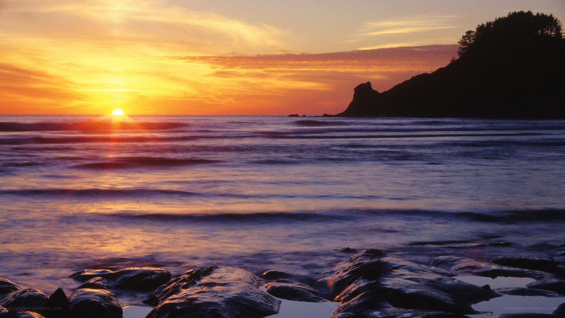 sunset over rocky coastline