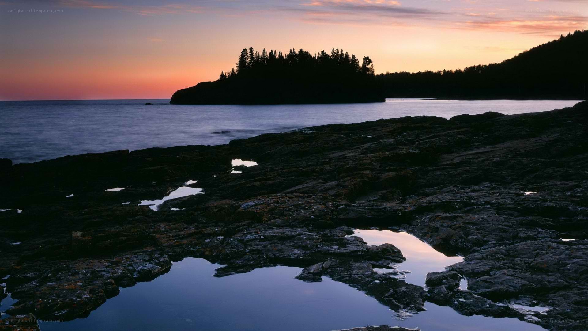 sunset over rocky coastline