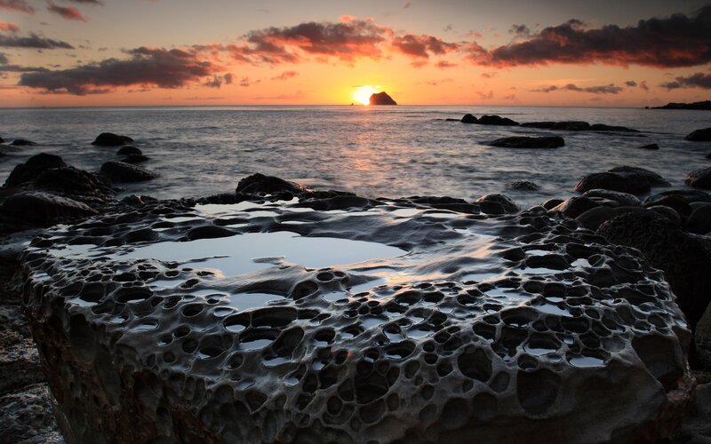 Sunset over rocky coastline