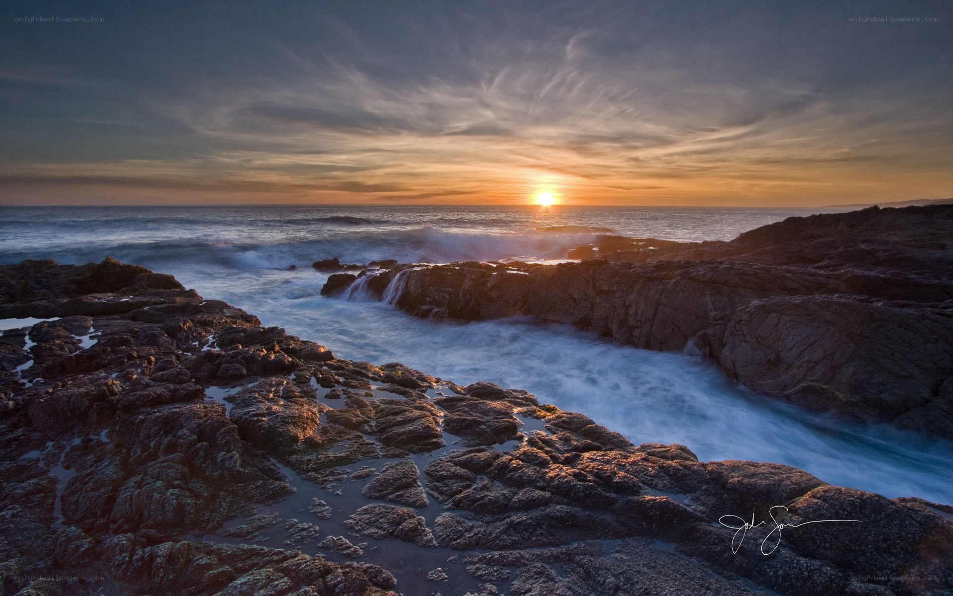 Sunset over rocky coastline