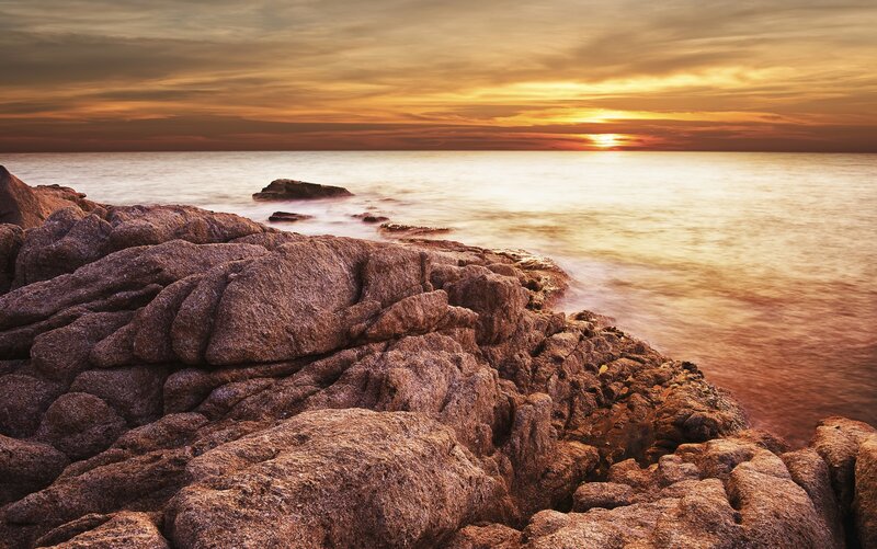 Sunset over rocky coastline