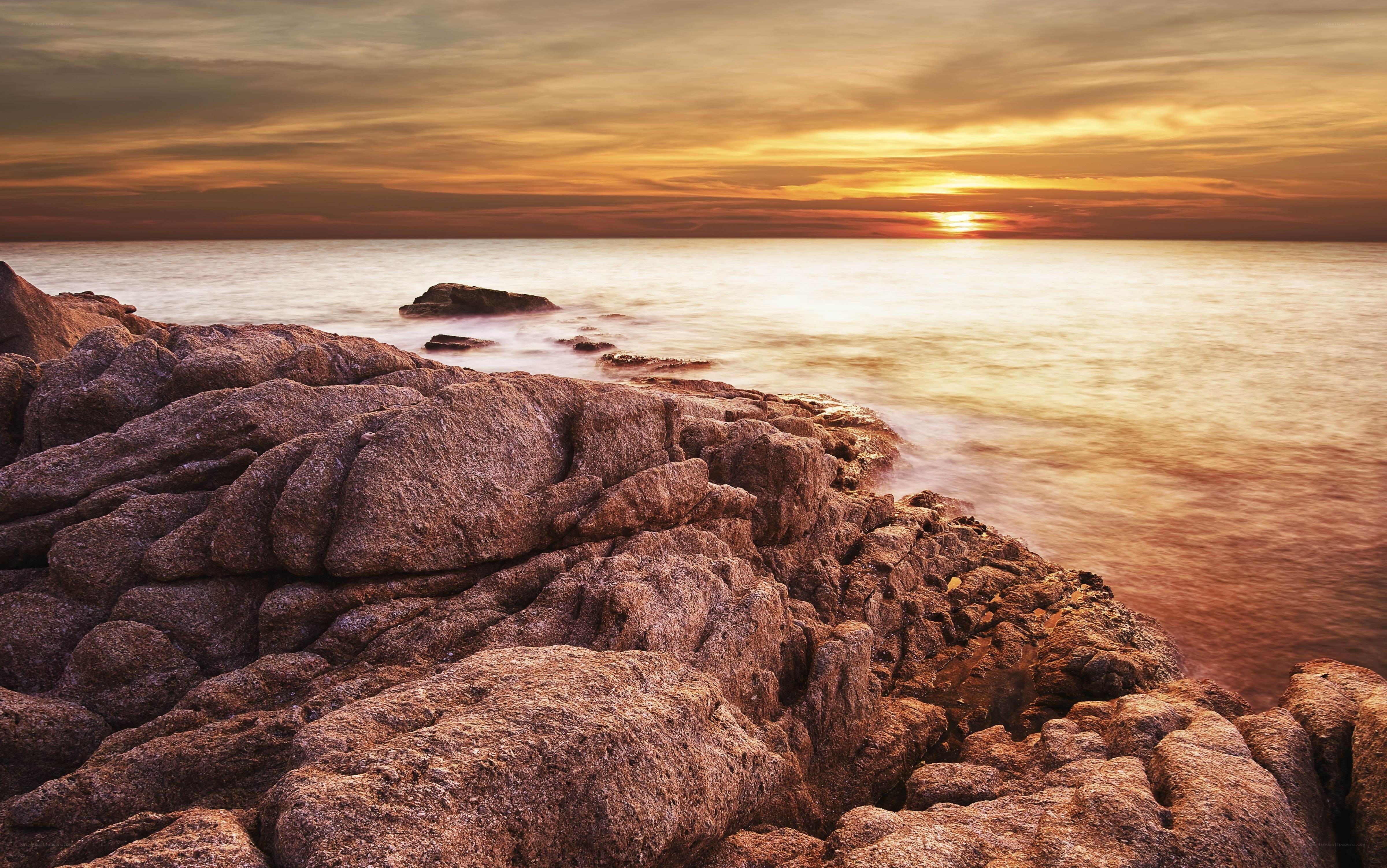 Sunset over rocky coastline