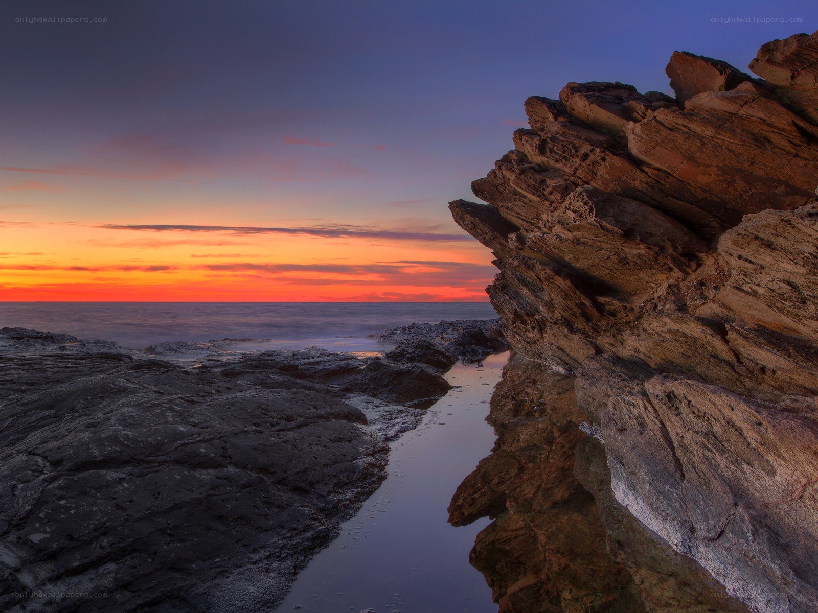 Sunset over rocky coastline