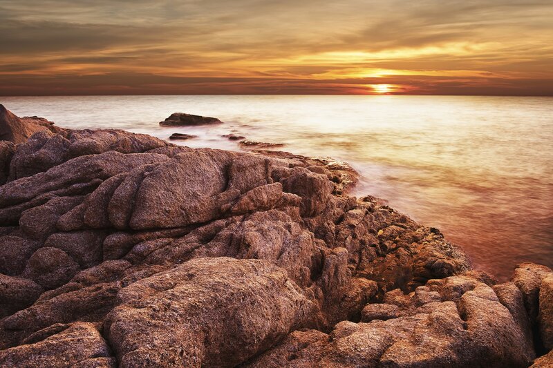 Sunset over rocky coastline