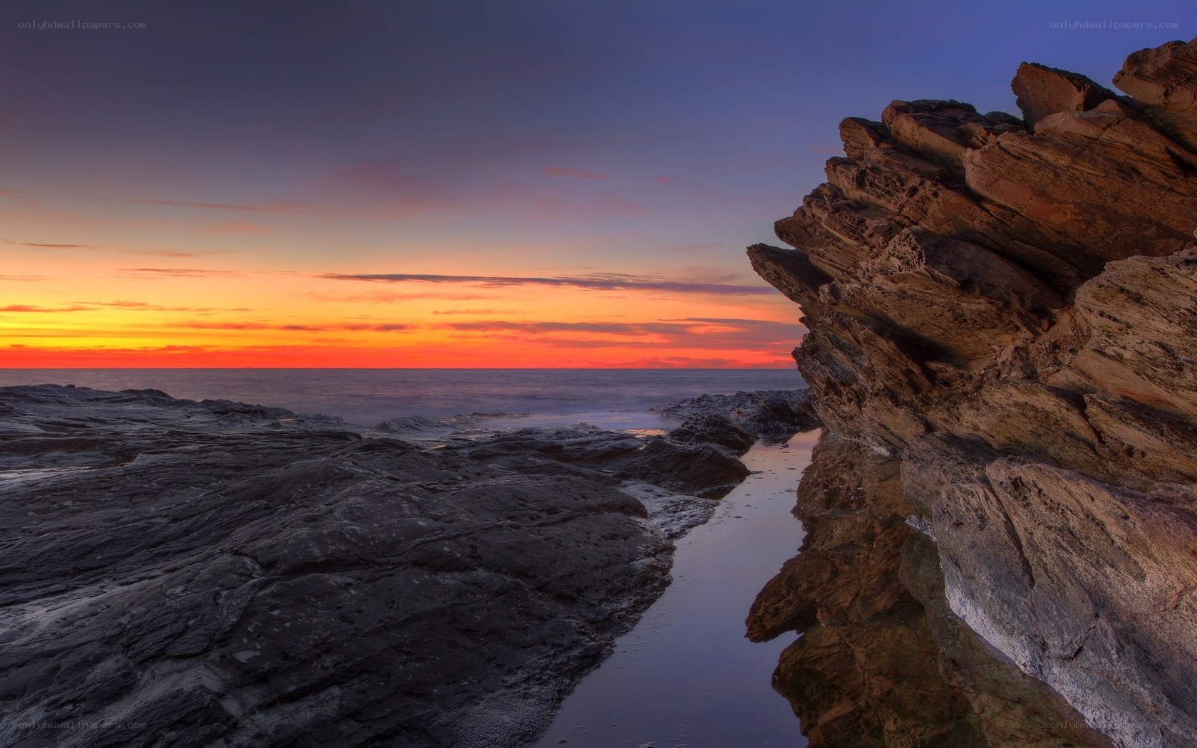 Sunset over rocky coastline