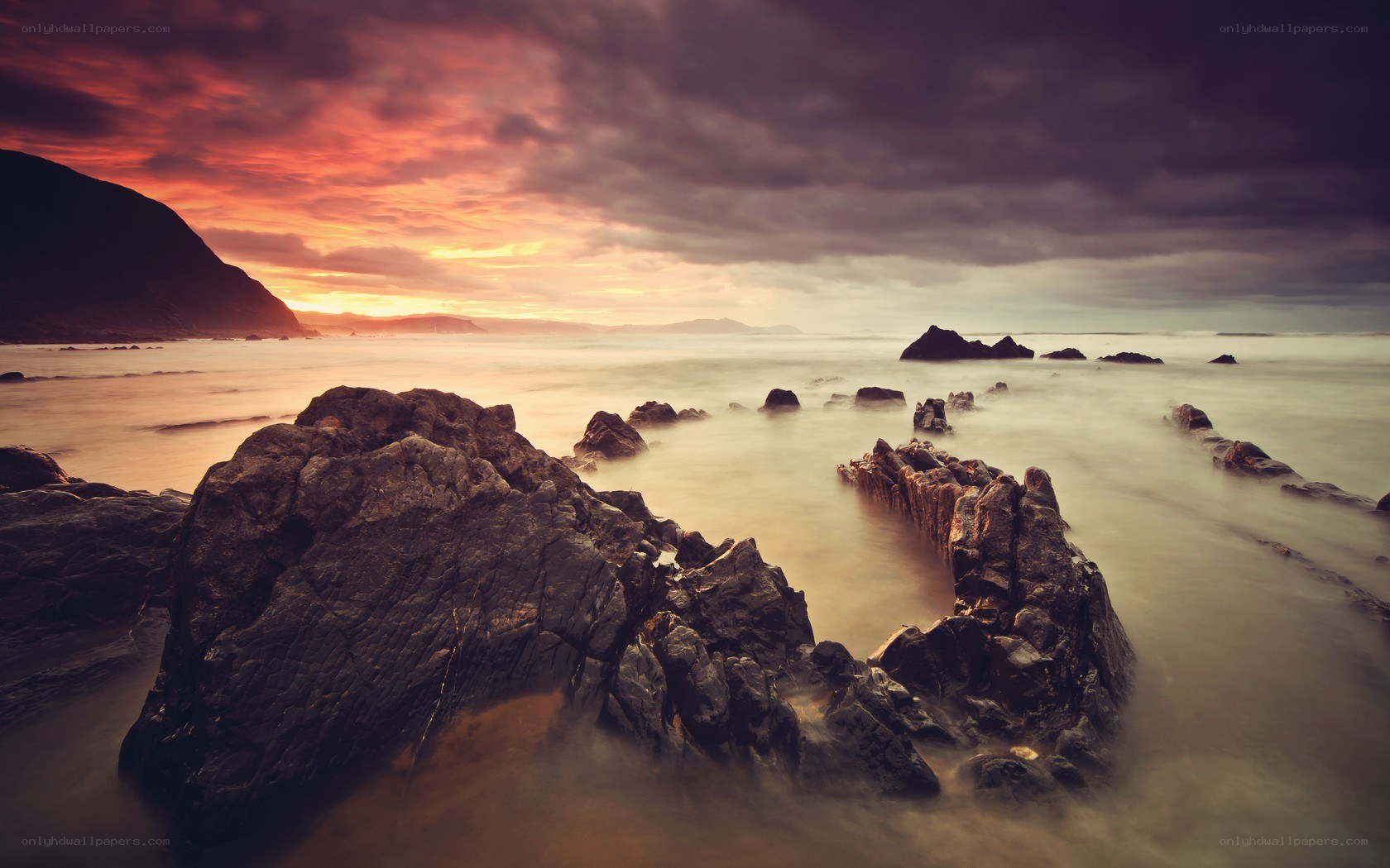 Sunset over rocky coastline