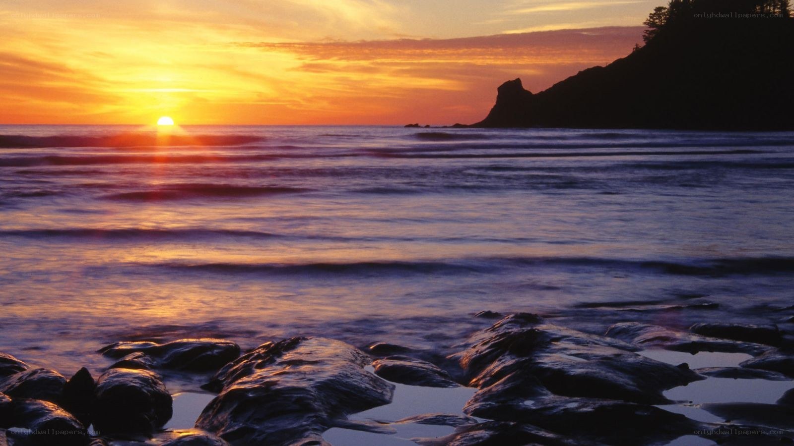sunset over rocky coastline