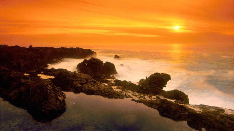 Sunset over rocky coastline