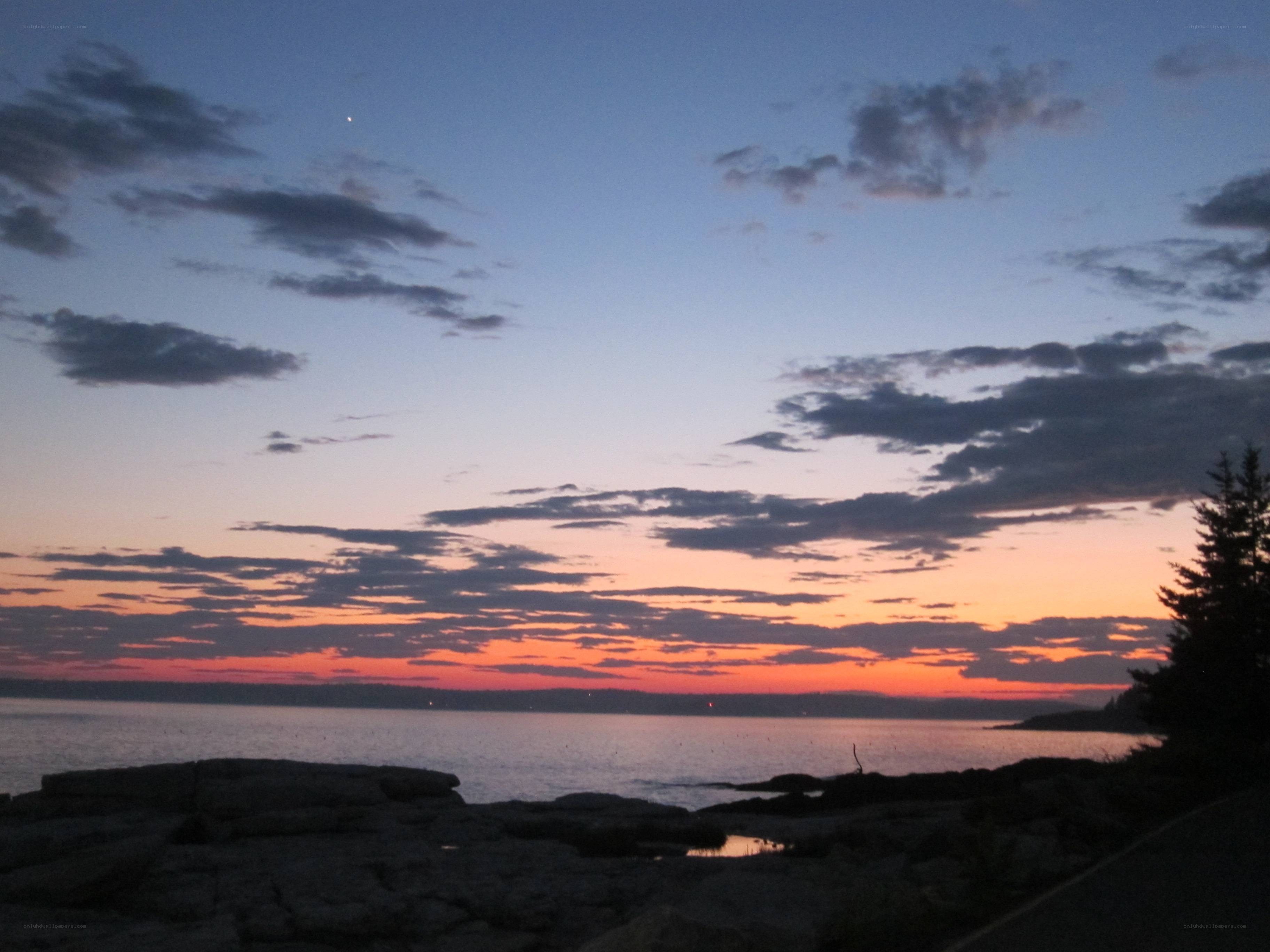 sunset over rocky coastline