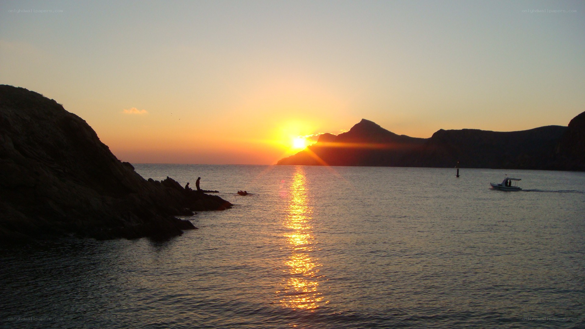 sunset over rocky coastline