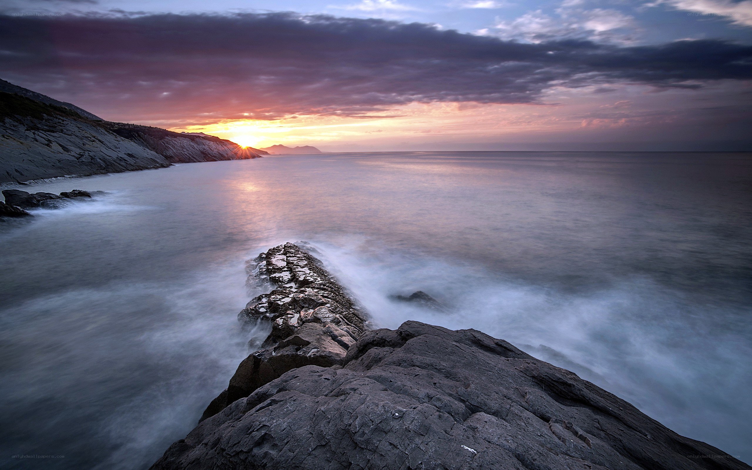 Sunset over rocky coastline