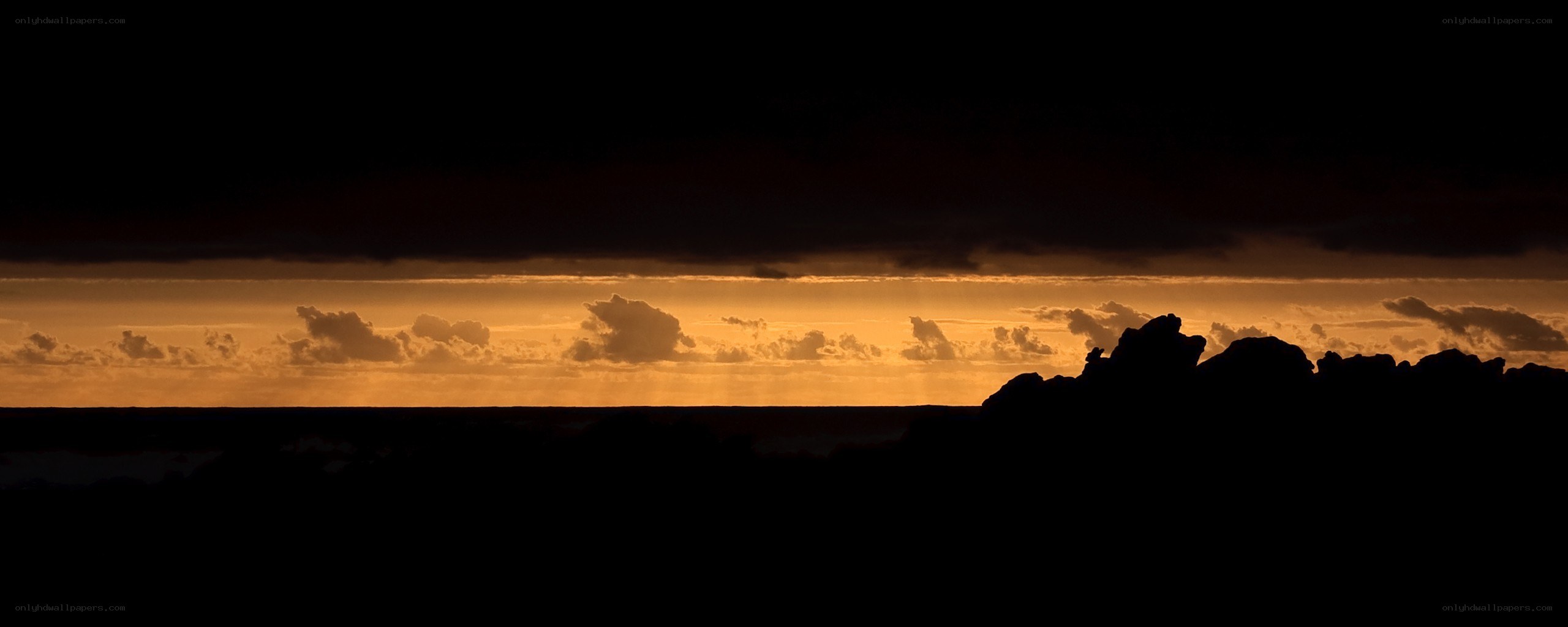 sunset over rocky coastline